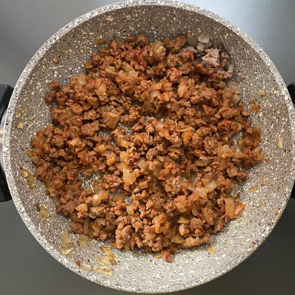 Фарш обжарить с луком и чайной ложкой томатной пасты